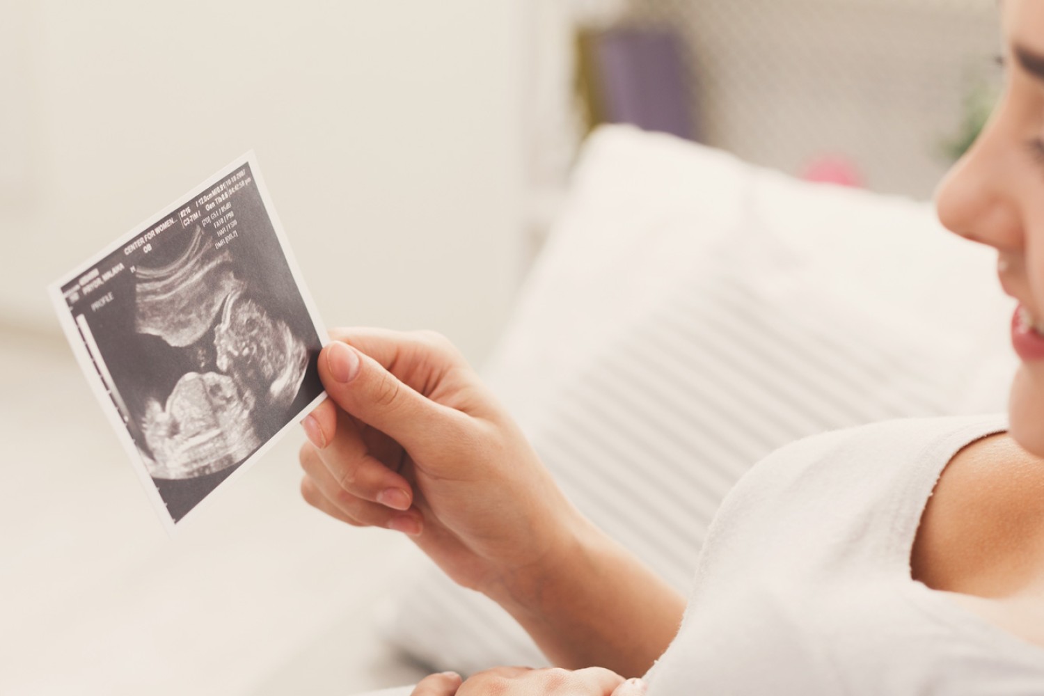 A happy pregnant woman watching a 3D scanned image of her baby