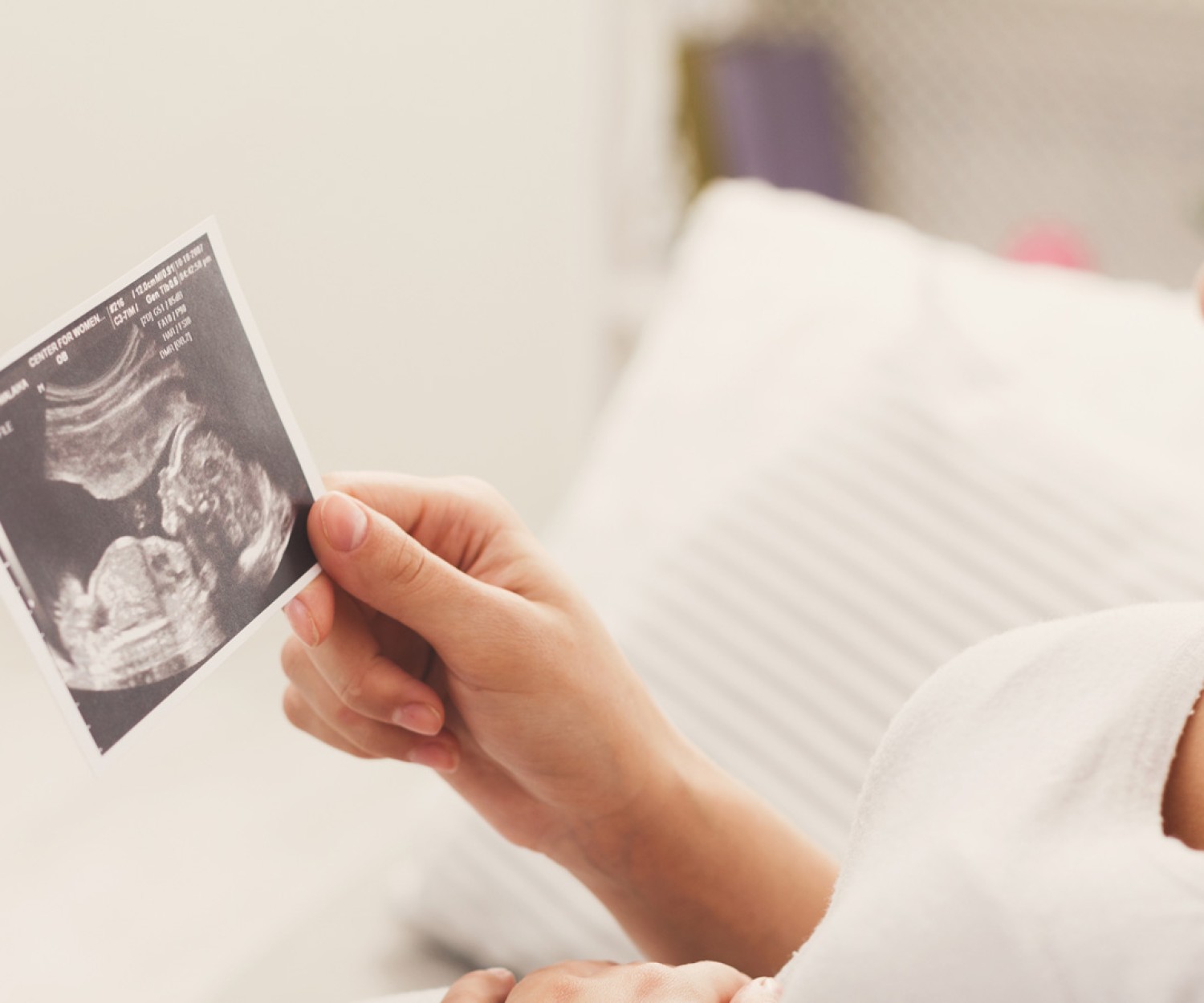 A happy pregnant woman watching a 3D scanned image of her baby