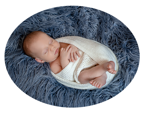 Newborn baby lying on blue fluffy bedding, top view