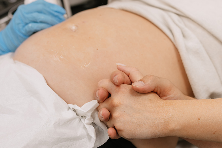 Gender-only scan at Yorkshire Baby Scan showing a pregnant woman’s belly with a supportive hand