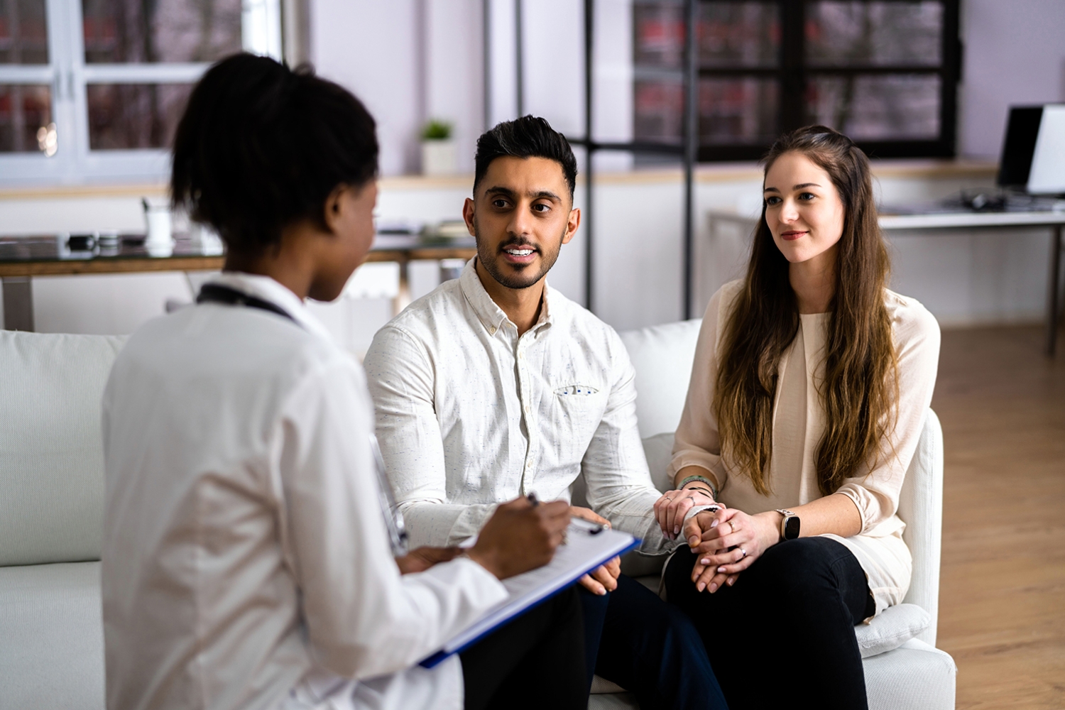 Pregnant couple discussing maternity care with a healthcare professional