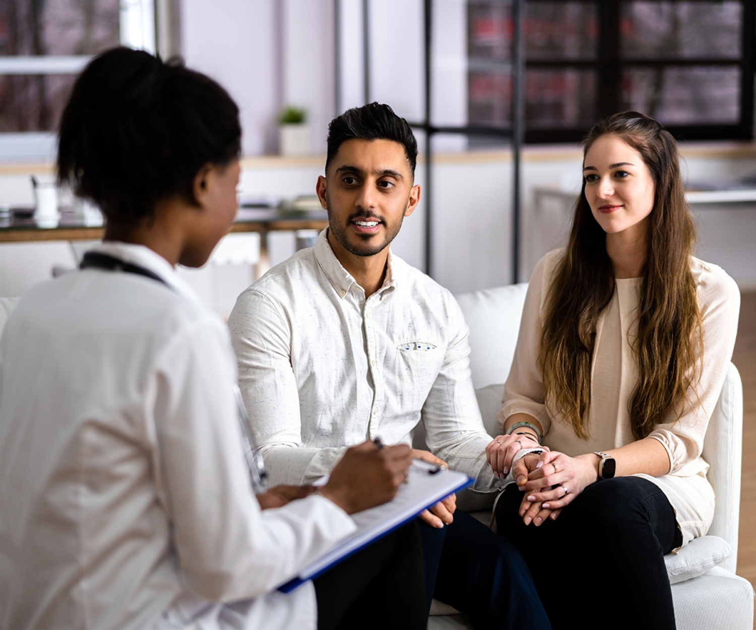 Pregnant couple discussing maternity care with a healthcare professional